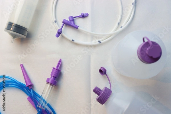 Obraz Syringe, bottle, infusion set and feeding tube for enteral nutrition infusion in a white background. Top view of Enteral nutrition objects in a white surface