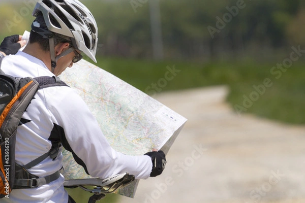 Obraz Man with bike checking map and looking around