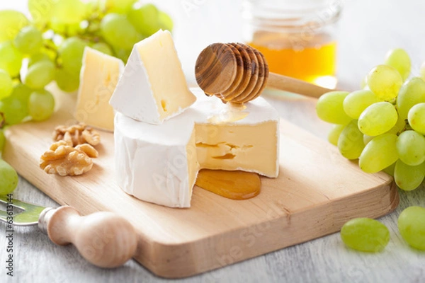 Obraz Ser Camembert z winogronami, miodem i orzechami na drewnianym backgroun