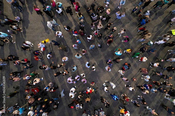 Fototapeta crowd people background. An aerial shot of the people gathered for an event. Crowed open-air meeting people shot from a height. A mass people gathered to celebrate an event. Open-air night festival.