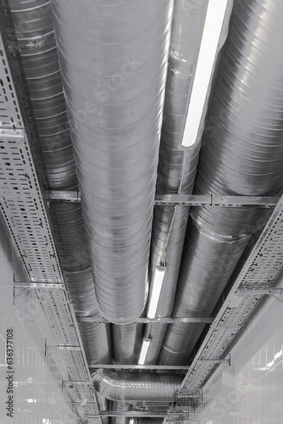 Fototapeta New installation of steel air conditioning duct pipes and  lighted dumps, installation of ventilation ducts during the renovation of building. Commercial cafe, restaurant, industrial space.