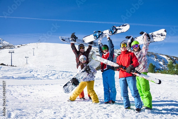 Fototapeta Pięciu snowboardzistów trzymających razem deski i narty