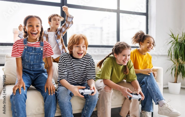 Fototapeta Group of joyful teenage friends with joysticks enthusiastically playing game console  .