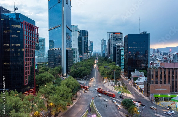 Obraz Aerial view of financial skyscrapers with moving bus and car on street during day in Mexico City under cloudy blue sky