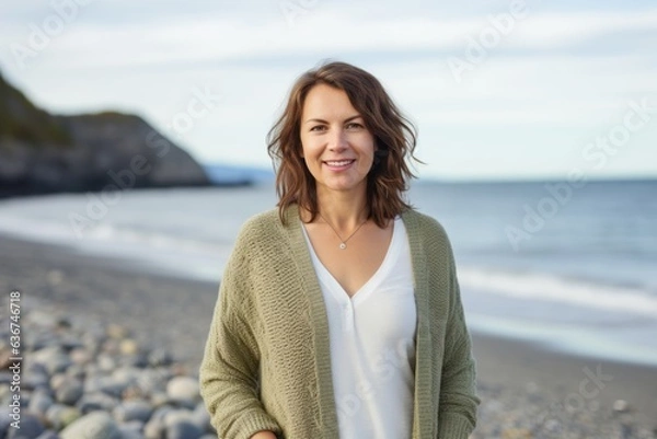 Fototapeta Portrait of a smiling woman standing on the beach at the seaside