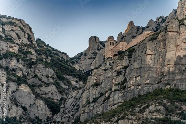 Fototapeta Low-angle view pf the famous Basilica de Monserrat on the high cliffs in Spain