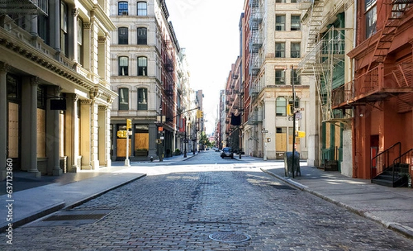 Fototapeta Empty streets and sidewalks of Soho are eerily quiet during the 2020 coronavirus pandemic lockdown in New York City with no people and sunset background