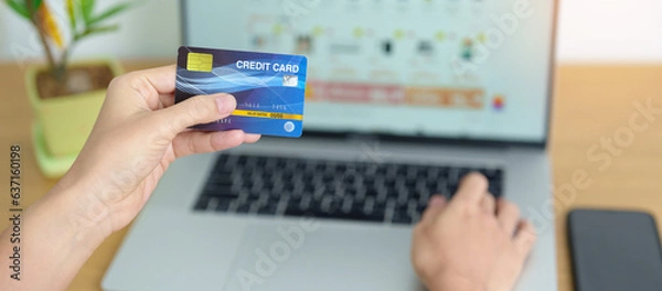 Fototapeta woman hand holding credit card and using laptop with mobile phone for online shopping while making order. Marketplace platform website, technology, ecommerce, digital banking and online payment