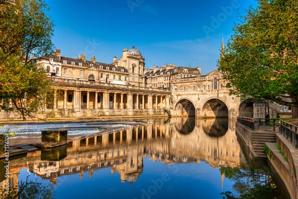 Fototapeta Pulteney Bridge and Weir on the River Avon in the historic city of Bath in Somerset, England, on a bright spring morning with deep blue sky. Stunning reflection, which is genuine.  