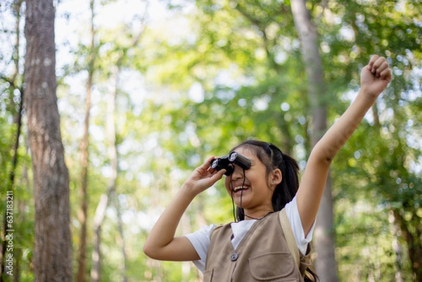 Fototapeta Happy Little Asian girls looking ahead and smiling child with the binoculars in the park. Travel and adventure concept. Freedom, vacation