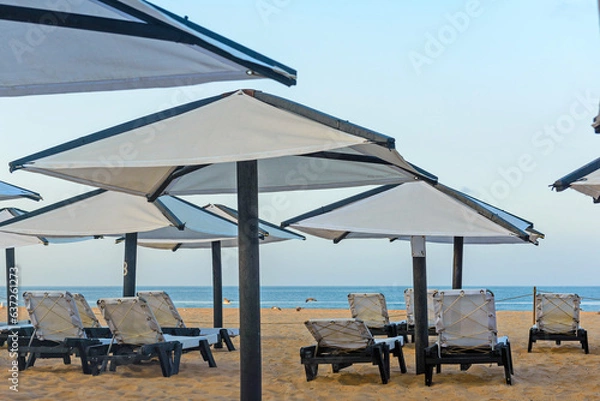 Obraz Sunbeds, Beach loungers, Relaxation, Beachside, Umbrellas,