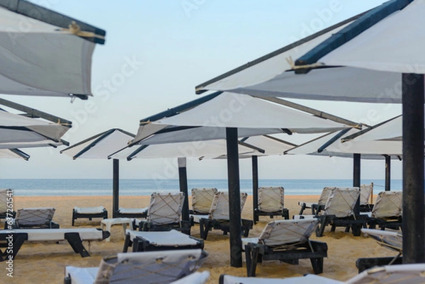 Fototapeta Sunbeds, Beach loungers, Relaxation, Beachside, Umbrellas,