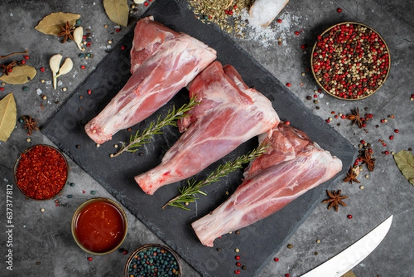 Fototapeta Lamb shank. Raw lamb shank meat on dark background. Butcher products. Top view