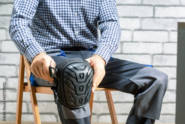 Obraz Builder wearing knee protection pads. Concept of safety protective equipment at construction site. Safety at work.