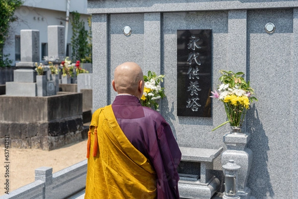 Obraz 永代供養墓の前で読経するお坊さん