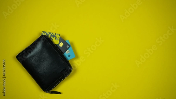Fototapeta Black Leather Wallet with Credit Cards On Yellow Backround. Top View. Space For Text
