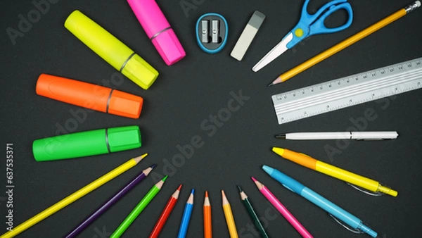 Fototapeta Various colorful school supplies lie in a circle on a black background. Back to school concept