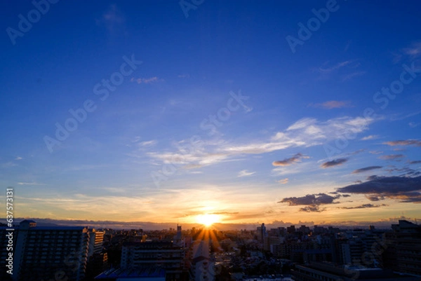 Fototapeta 都市の夜明け。東の空が明るくなり雲がまだ昇る前の太陽に照らせら美しいグラデーションを見せる。神戸市内から大阪方面を臨む。