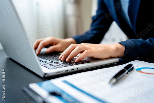 Fototapeta Businesswomen or Accountants using laptops working analyzing business report graphs and finance charts at the workplace, financial and investment concepts.