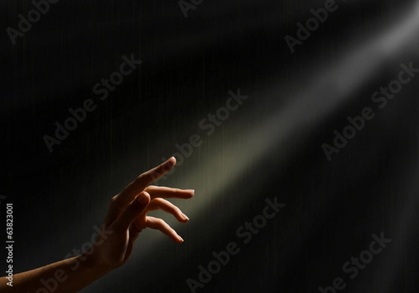 Obraz kobieca ręka sięga po promienie światła