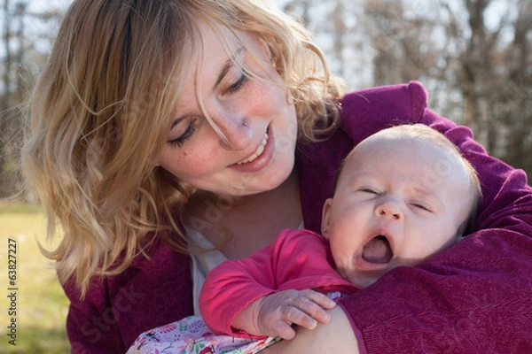 Fototapeta Baby is yawning in mothers arms