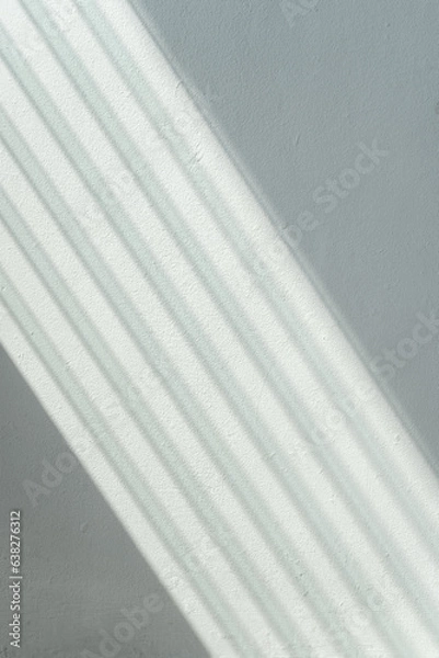 Fototapeta Light Shining Through Glass Louvers Window On The Blue Pastel Color Wall Pattern Background, Soft Light Pattern On The Blue Pastel Color Wall, Sun Shining Through Window Blinds