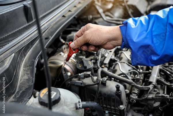 Fototapeta 동네 카센터에서 자동차의 보닛을 열고 엔진오일을 체크하는 엔지니어
