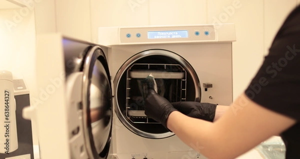 Fototapeta Disinfection of dental instruments in an autoclave. The process of using an autoclave to disinfect medical instruments.