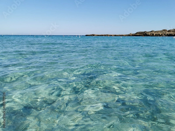 Obraz Fig Tree Bay beach, crystal clear water, white sand at the bottom, small island off the coast.