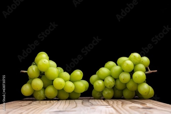 Fototapeta 板の上のシャインマスカットを黒背景で撮影した写真