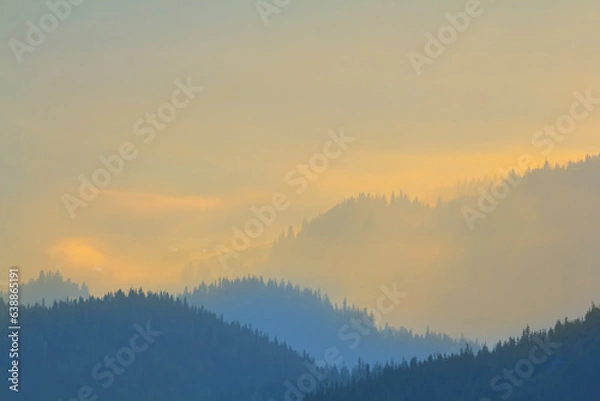 Fototapeta mountain ridge silhouette in blue mist, early morning mountain background