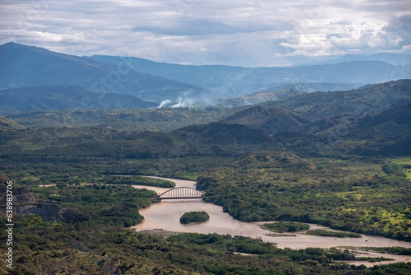 Fototapeta Aerial view of an iron bridge that crosses a river in a Colombian landscape
