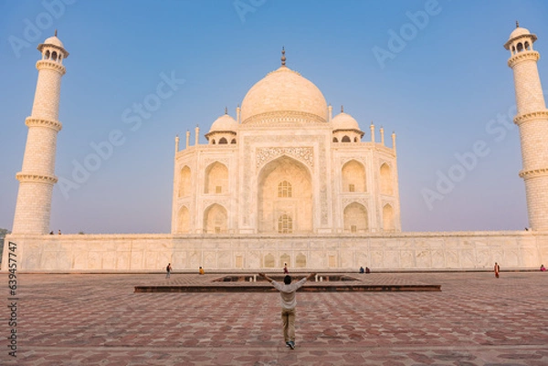 Fototapeta The man with arms around his back standing in front of Taj Mahal indian palace. Islam architecture. 