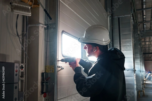 Fototapeta Engineer repairing an unloading gate