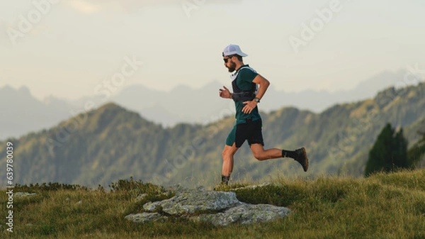 Fototapeta Young man runs in the mountains