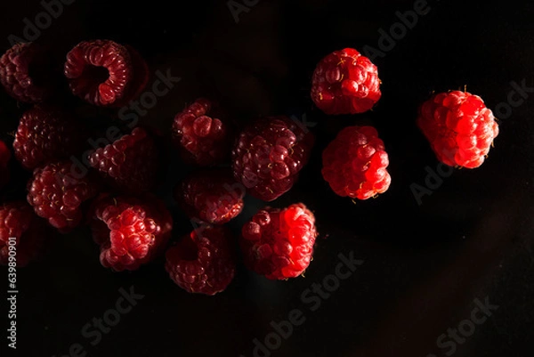 Obraz ripe red raspberries on a dark background