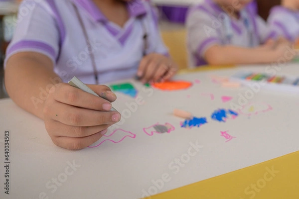 Fototapeta Children draw and paint water or crayons on the colorful drawing paper of their own creativity in the kindergarten class at the school.