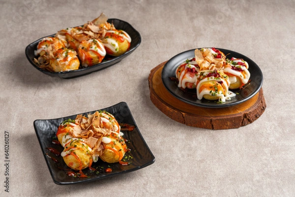 Fototapeta Takoyaki is a ball-shaped Japanese snack made of a wheat flour-based batter and cooked in a special molded pan
