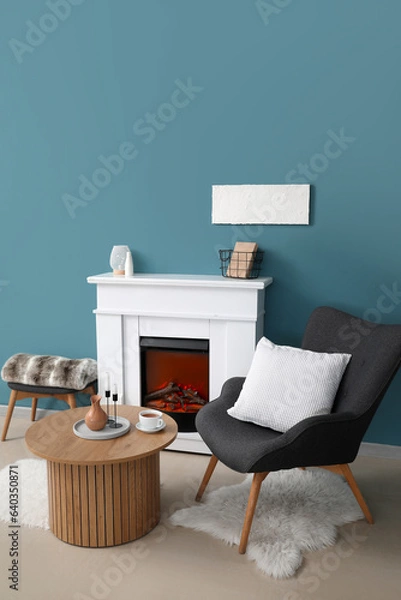 Fototapeta Coffee table with cup of tea, jug and candles in living room