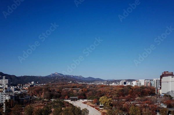Fototapeta 푸른 하늘이 펼쳐진 서울 옥상에서 본 가을 산과 문화 유산 풍경