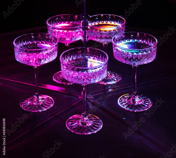 Obraz A glass of wine reflected in mirrors and illuminated by colored light