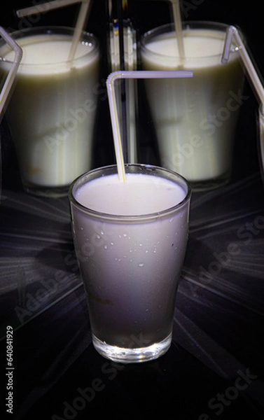 Obraz glasses with a milkshake reflected in mirrors and illuminated by colored light