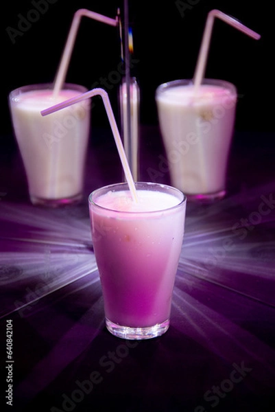 Obraz glasses with a milkshake reflected in mirrors and illuminated by colored light