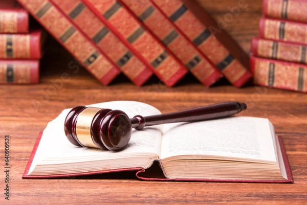 Fototapeta Legal Law and Justice concept - Open law book with a wooden judges gavel on table in a courtroom or law enforcement office. Copy space for text.