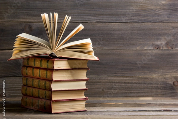 Fototapeta Open book, hardback books on wooden table. Back to school. Copy space	