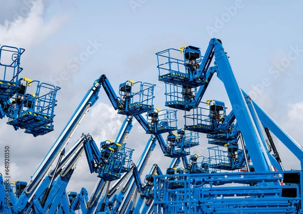 Fototapeta Group of aerial work platforms for construction and material handling. Close-up to the basket for moving people