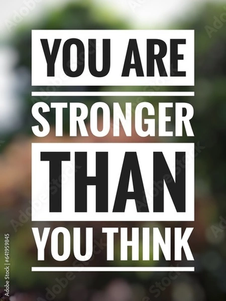 Fototapeta Motivational quote "You are stronger than you think" on blurred nature background.