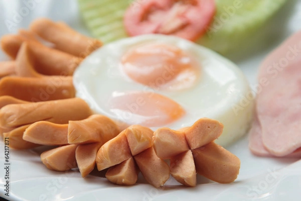 Fototapeta Breakfast with sausage, bacon, fried egg and vegetable