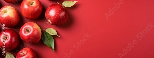 Fototapeta Red apples with leaves on red background
