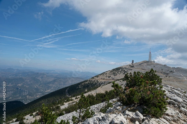 Obraz The top of the Mont Ventoux in Vaucluse at 1910m.  The observation tower is on the right of the picture. A blue and cloudy sky. Trees in the foreground.